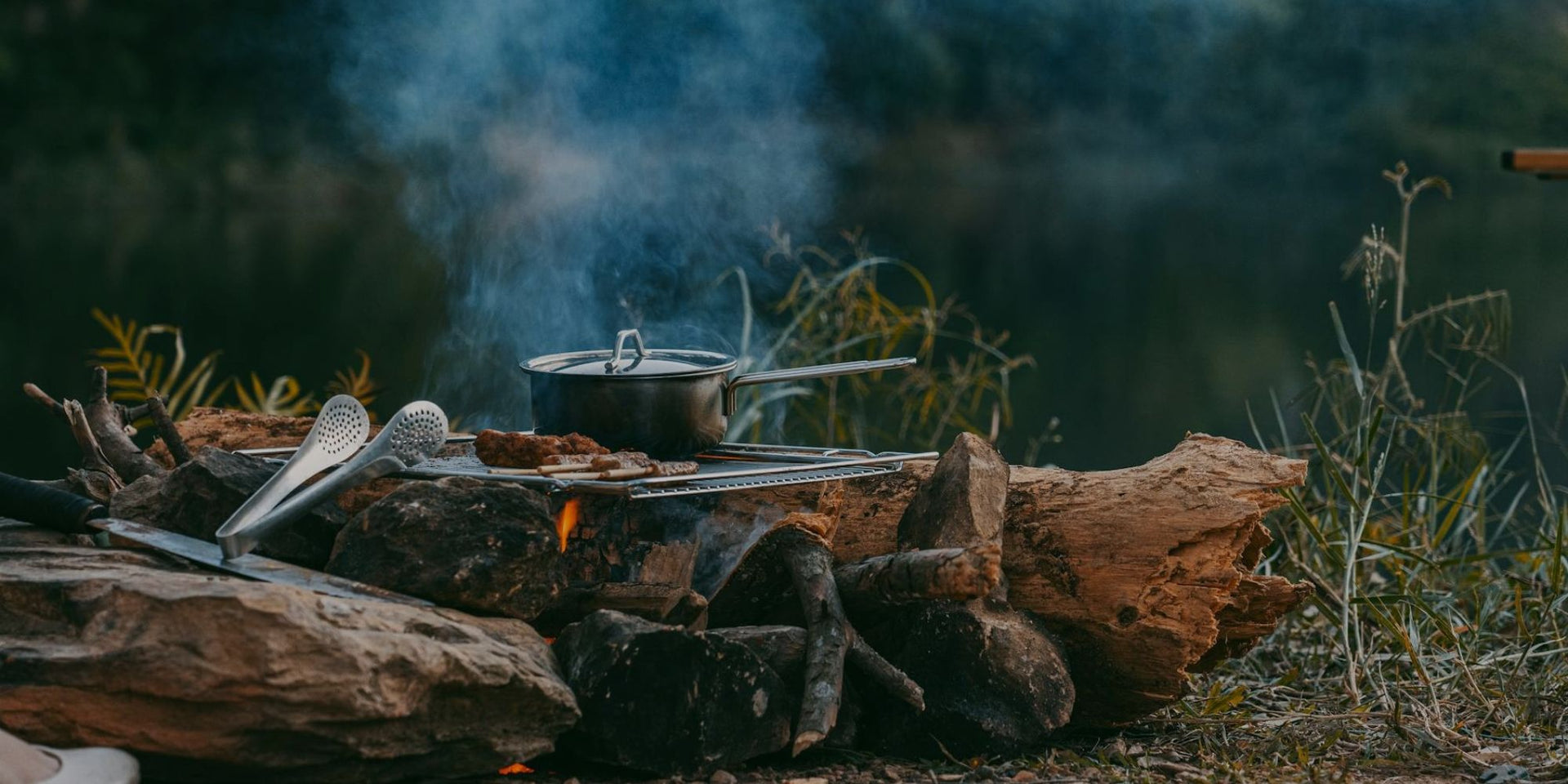Cooking pot on a campfire with smoke in a natural setting